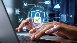Someone types on a laptop keyboard while a glowing shield icon with a lock and a check mark, symbolizing data protection, hovers above their hands; Copyright: Adobe Express