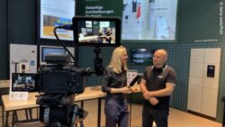 The editorial team conducts a video interview at EuroShop 2026 as a camera records the conversation. 