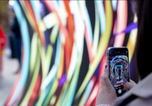 A person shot from behind using a smartphone camera to capture colorful colors and a person; copyright: Messe Düsseldorf/Andreas Wiese
