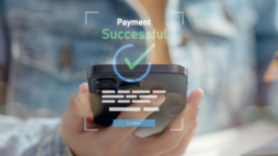 Smartphone displays confirmation message “Payment Successful” with a green check mark, held by a person; Copyright: Adobe Express